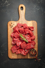 Diced cut raw beef cubes wooden cutting board red meat cooking protein top view