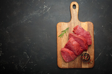 Raw beef steaks cooking preparation rosemary pepper red meat cutting board copy space