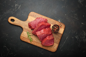 Raw beef steaks cooking preparation rosemary pepper red meat cutting board