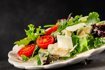 Parmesan cheese vegetable salad tomato, arugula, green leaf lettuce healthy food main course ingredient appetizer fresh tasty gourmet food background food top view copy space vegetarian food