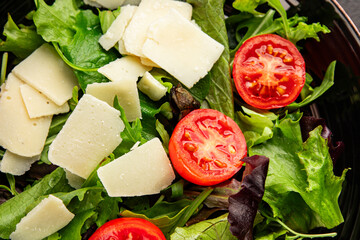 Parmesan cheese vegetable salad tomato, arugula, green leaf lettuce healthy food main course ingredient appetizer fresh tasty gourmet food background food top view copy space vegetarian food