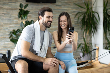 A man and woman share a laugh while enjoying their workout, highlighting joy and connection during fitness.