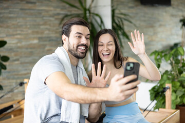 Obraz premium A joyful moment of a man and woman sharing smiles and stories during a break in a sleek fitness studio.