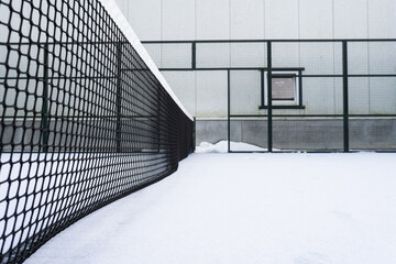 Snow-covered outdoor padel courts, showcasing the direct impact of climate and winter conditions on the accessibility of this popular sport. Weather-related features, and seasonal activities.