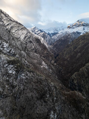 Winter landscape in Bulgaria, Balkan Mountains, with snow-covered hills and scattered pine trees under a blue sky. Peaceful rural scenery, natural wilderness, cold season, wide panoramic view