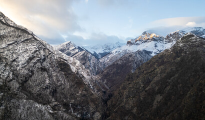 Winter landscape in Bulgaria, Balkan Mountains, with snow-covered hills and scattered pine trees under a blue sky. Peaceful rural scenery, natural wilderness, cold season, wide panoramic view