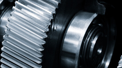 Close-up of  gear with many details. gear silver with many diagonal teeth, against an industrial...