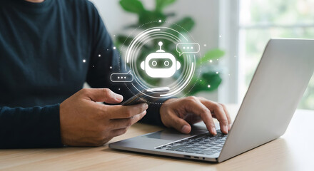 Man using laptop and smartphone to interact with AI chatbot assistant for customer support and business automation in modern office setting with digital robot icon interface