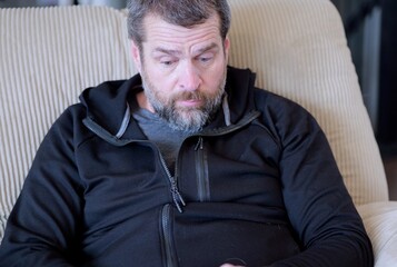 Obraz premium Middle Aged Man Gets Mobile Phone Notification of Suspicious Foreign Banking Transactions - FinTech Cybersecurity Mobile Banking Alerts Concept