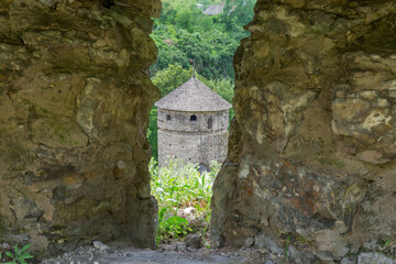 Ancient defensive tower through the loophole in stone defensive wall