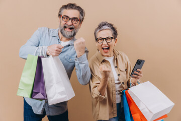 Happy senior couple celebrating shopping success