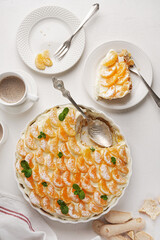 Tangerine tiramisu orange tiramisu on the plate and dish on white table, top view