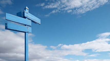 A weathered blue wooden directional sign against a vibrant blue sky dotted with puffy white clouds