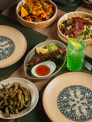 A delicious gourmet meal of traditional Indian food features healthy vegetarian dishes and hot meat curries served with rice and spices on a restaurant table