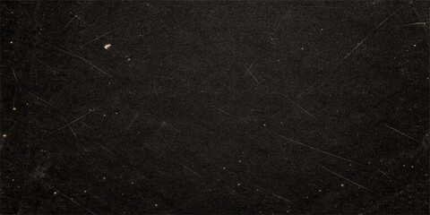 A dark and rough grunge paper texture featuring a black and white macro pattern on an old blank surface for use as a grey textured material backdrop or wallpaper design