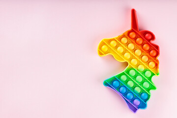 Rainbow Unicorn Pop It Fidget Toy on Pink Background with Copy Space Sensory Anti Stress Concept