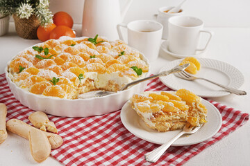 A piece of Tangerine tiramisu on the plate on red napkin, Italian dish, christmas dessert