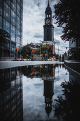 Historic Church Tower in Hamburg Reflected in Urban Waterway, Moody Evening Atmosphere