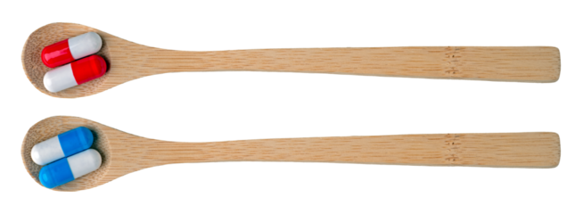 Wooden spoon and colorful capsules arranged two to a spoon. Isolated background.