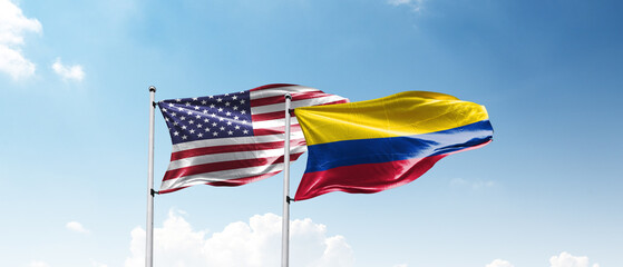 USA and Columbia Flags Flying Together Against Blue Sky