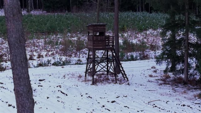 Tower used by hunters to wait and lure for animals to shoot. In the edge of the forest in winter time