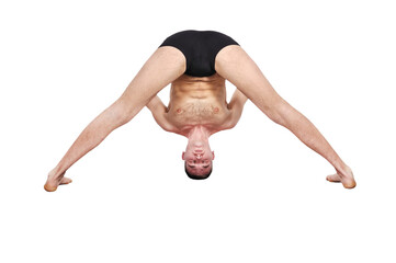A muscular man doing a yoga asana.