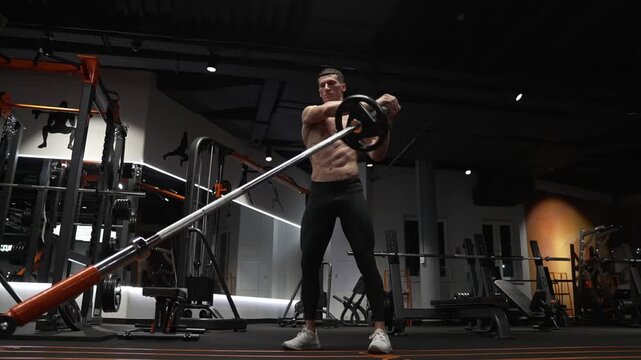 Athletic man performing landmine exercises with barbell. Strength and fitness. Muscular sportsman in sport gym do landmine exercise. Sport sportsman with barbell landmine in gym