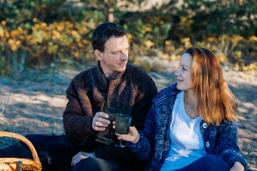 Portrait happy beautiful couple in love enjoying autumn picnic in autumn park. High quality photo