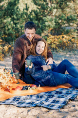 Portrait happy beautiful couple in love enjoying autumn picnic in autumn park. Vertical photo. High quality photo