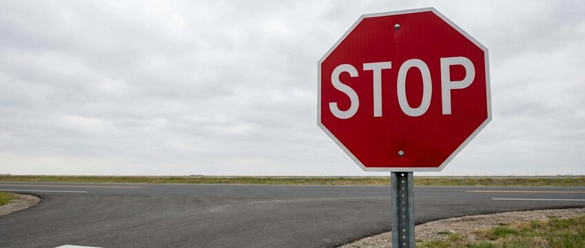 Red Stop Sign at Rural Road Intersection Under Overcast Sky