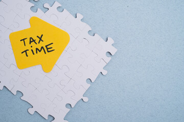 Tax preparation puzzle. Tax time reminder on jigsaw puzzle background