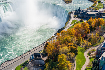Overlooking the Niagara Falls Horseshoe Falls in a sunny day in autumn foliage season. Niagara Falls City, Ontario, Canada.