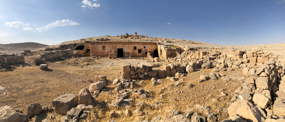 A panoramic view of ancient settlements carved into the rocks and stone structure ruins. A historical site in the geography of Mesopotamia.