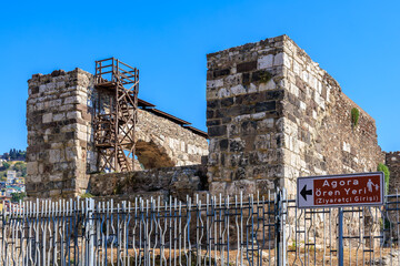 Ancient agora ruins with sign. Turkish inscription: Agora Archaeological Site (Visitor Entrance)