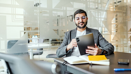 Business meeting in office with a man using a tablet
