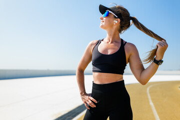 Woman running on track wearing sports gear