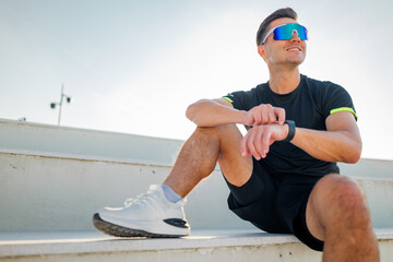 Man sitting on steps while wearing sports gear
