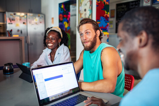 Young adults smiling during a casual meeting in a coworking space