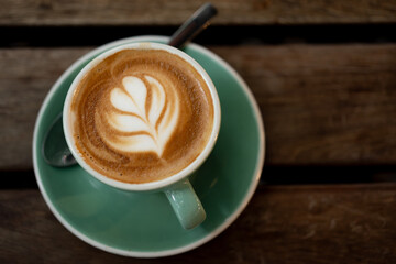 cup of coffee on wooden table with a love heart latte art
