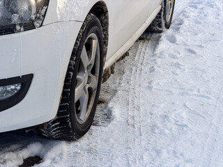 Close u of a car wheel standing on snow covered road 