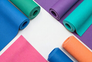 Yoga mats arranged in different colors on a surface ready for use during a workout session at a fitness center