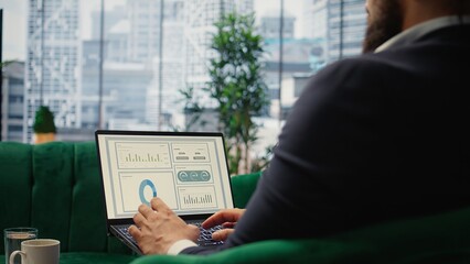 Confident leader reviews sales trends and budget reports in his smart office, ensuring profitability and company success through effective decision making and strategic planning. Camera A.