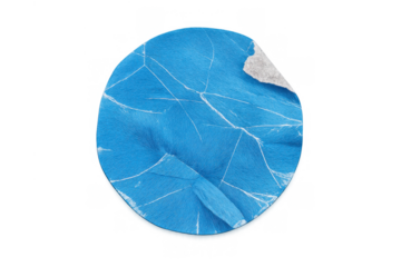 Blue crumpled round sticker with creased paper texture and peeling corner, isolated on transparent background