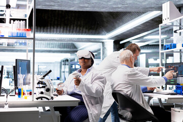 Woman expert in laboratory using VR headset to simulate experiment and research study. Virtual reality tech supporting microbiology and advanced medical discovery in healthcare.