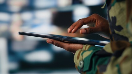 Close up of army soldier using tablet radar software to track hostile threats. African american woman in command center using target acquisition tech on device to detect enemy location
