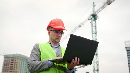 Man inspects territory of construction site outside, use gadget