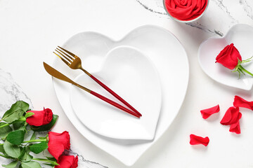 Table setting for Valentine's Day with rose flowers and petals on marble background