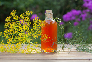 dill essential oil in  beautiful bottle on wooden background