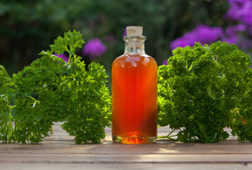Essence of herbs on table in beautiful glass jar