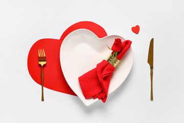 Table setting for Valentine's Day with rose flower and decorative heart on white background